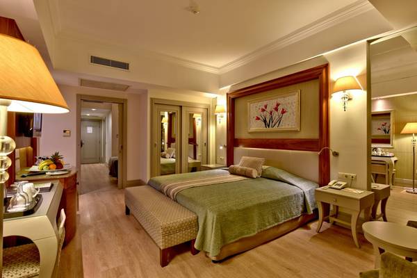 Innenansicht eines Hotelzimmers im Side Star Resort mit Doppelbett, Nachttischen und Lampe.