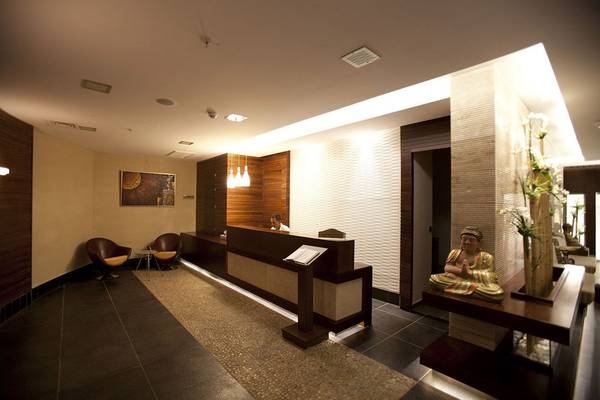 Empfangsbereich des Side Star Resorts mit Rezeption, Buddha-Statue und geometrischen Wandverkleidungen.