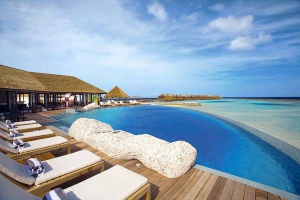Außenpool des Lily Beach Resort & Spa mit Lounge-Sesseln und Blick auf das Meer