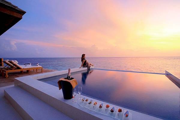 Frau genießt den Ausblick am Pool des Lily Beach Resort & Spa
