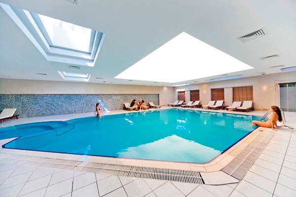 Innenpool des Side Star Resort mit mehreren Sonnenliegen und Personen.