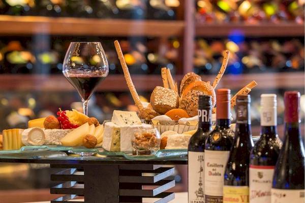 Wein und Käseplatte im Lily Beach Resort & Spa mit verschiedenen Käsesorten, Nüssen und Brot.