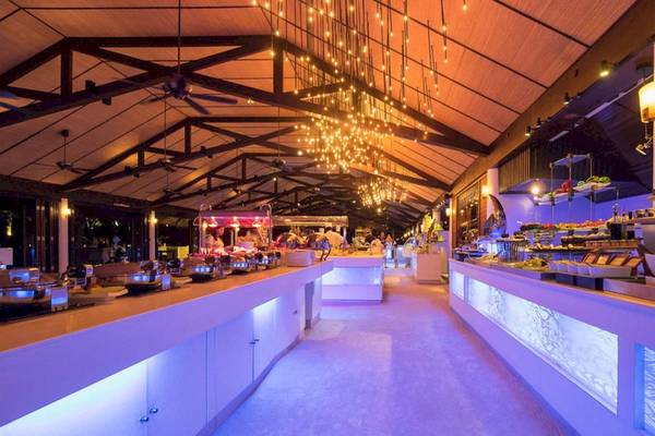 Buffetbereich im Lily Beach Resort & Spa mit gedeckten Tischen, Beleuchtung und Gästen.