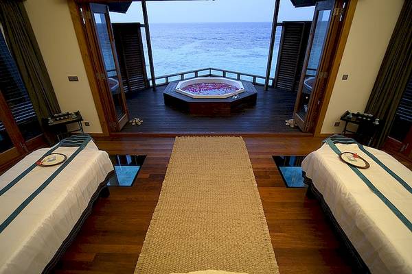 Massageraum im Lily Beach Resort & Spa mit Blick auf das Meer, inklusive Jacuzzi und zwei Betten.