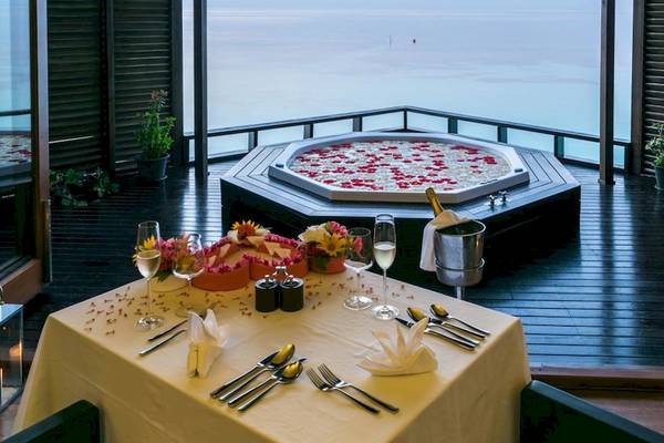 Romantisches Dinner auf der Terrasse im Lily Beach Resort & Spa mit Blick auf das Meer und einem Whirlpool.