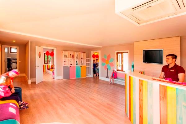 Kinderbereich im Side Star Resort mit bunten Wänden und Möbeln, Rezeptionist und Gäste