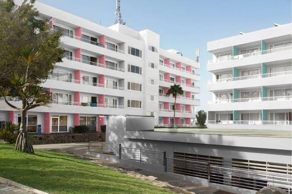 Außenansicht des Abora Interclub Atlantic Hotels mit weißen Gebäuden und rosa Säulen.