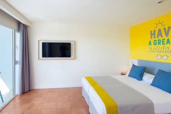 Hotelzimmer im Abora Interclub Atlantic mit Doppelbett, Fernseher und gelber Wand