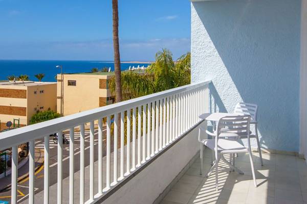 Balkon mit Meerblick im Abora Interclub Atlantic Hotel, zeigt eine Tisch mit Stühlen und Palmen.