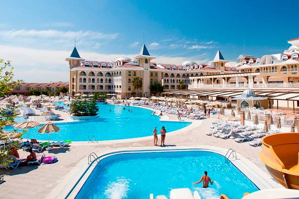 Außenansicht des Side Star Resort mit zwei Swimmingpools, Sonnenliegen und Gästen.