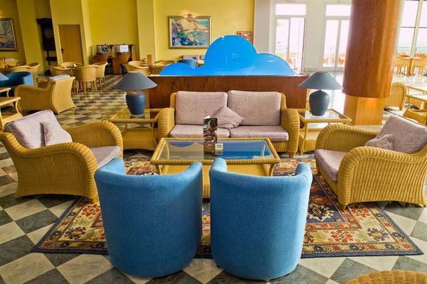 Lobby des Mogan Princess & Beach Club Hotels mit gelben Stühlen, Sofas und Teppichen.