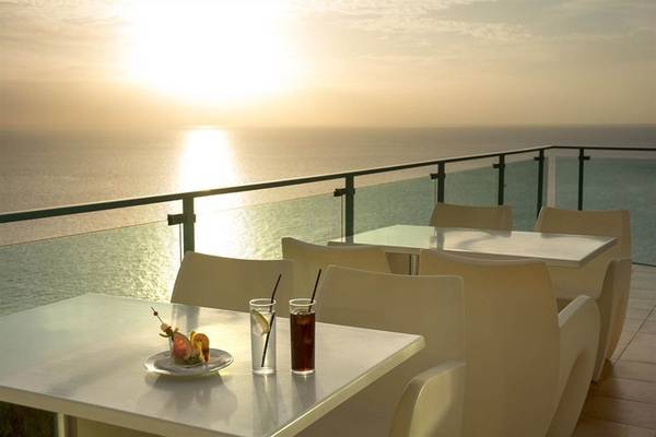 Terrasse des Mogan Princess & Beach Club mit Blick auf den Ozean bei Sonnenuntergang.