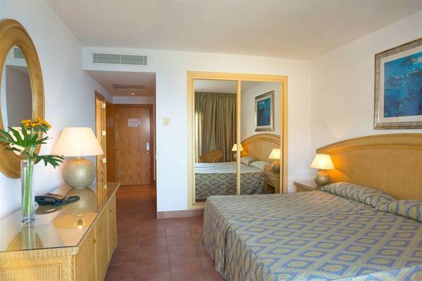 Hotelzimmer des Mogan Princess & Beach Club mit Doppelbett, Nachttischen und Lampen.