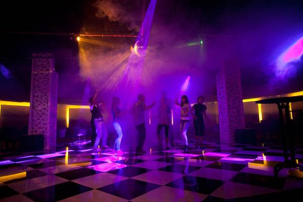 Gruppe von tanzenden Gästen auf der Disco-Fläche des Side Star Resorts mit Lichteffekten.