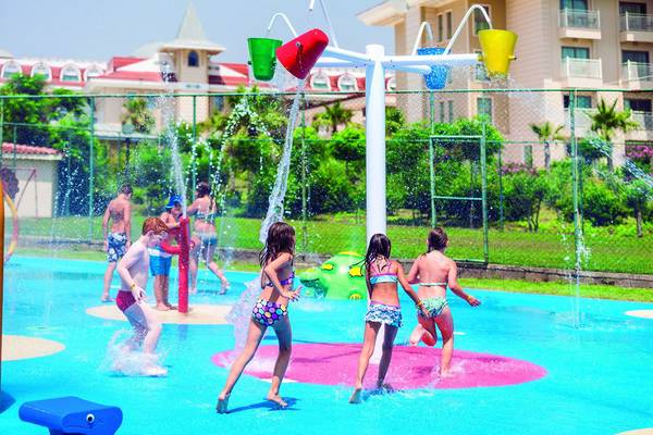 Kinder spielen auf einem Wasserspielplatz im Freibad des Side Star Resort.