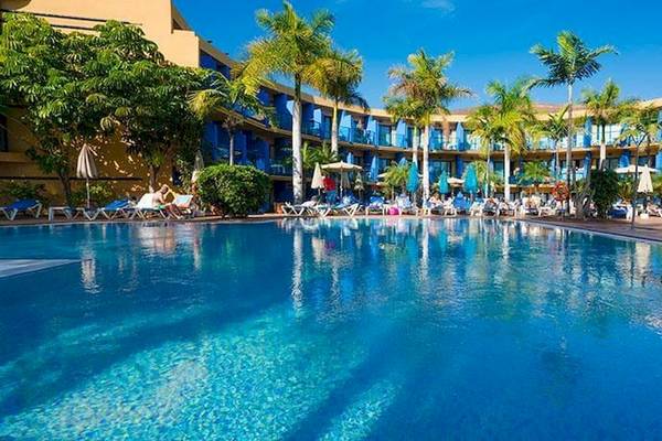 Poolbereich des Bluesea Costa Bastian Hotels mit blauen Gebäuden und Sonnenliegen