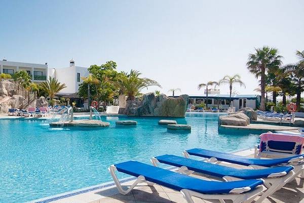 Schwimmpoolbereich des Hotels Bluesea Costa Bastian mit Liegestühlen und Wasserrutsche.