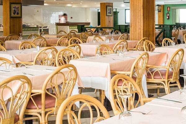 Das innenbereich des Bluesea Costa Bastian Hotels mit eingerichteten tischen und stühlen.