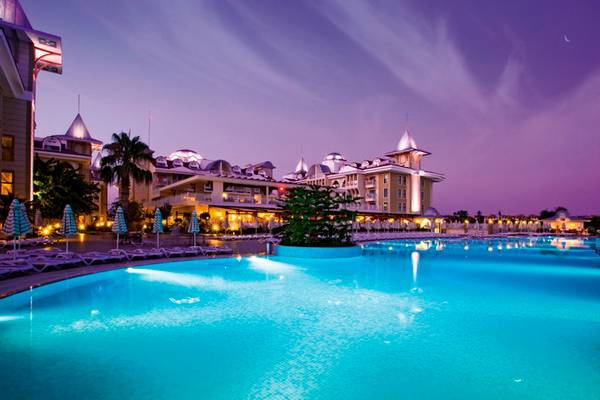 Außenpool des Side Star Resorts bei Nacht mit illuminiertem Hotel im Hintergrund.