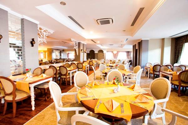 Innenansicht des Restaurants im Side Star Resort mit gedeckten Tischen und Stühlen.