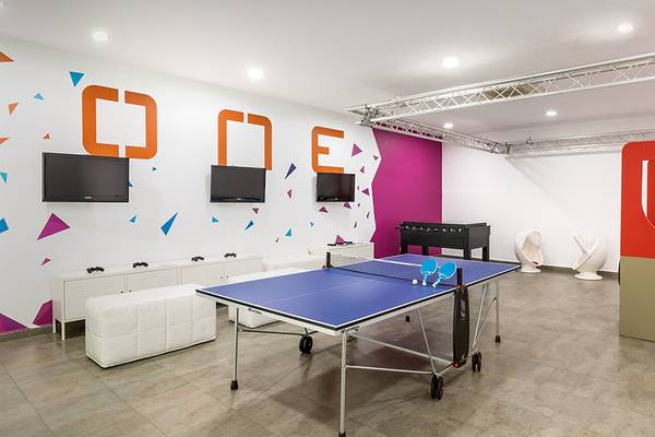 Spielzimmer im Barcelo Santiago Hotel mit Tischtennistisch, Fernsehern und bunten Wänden.
