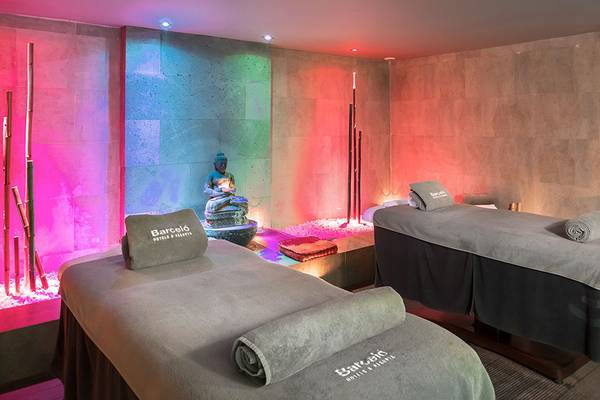 Behandlungsraum im Barcelo Santiago Hotel Spa mit zwei Massagetischen und bunten Lichtern.