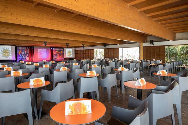 Ein Konferenzraum im Barcelo Santiago mit vielen Tischen und Stühlen, Holzdecken und Projektionsbildschirmen.