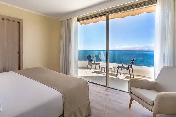 Hotelzimmer mit Meerblick im Barcelo Santiago, inklusive Bett, Sessel und Terrasse.