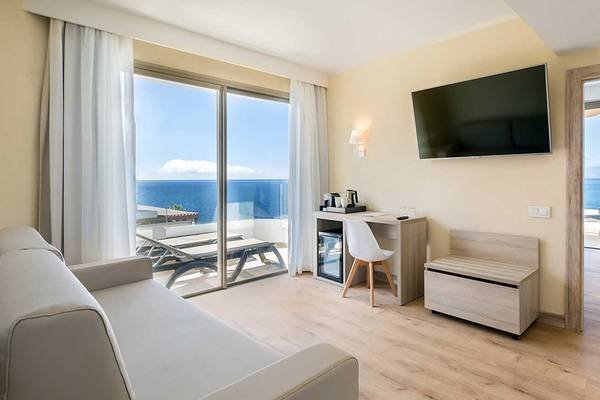 Hotelzimmer des Barcelo Santiago mit Meerblick, Fernseher, Schreibtisch und Balkon.