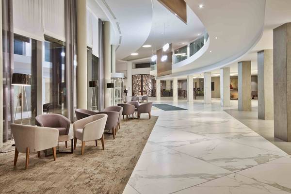 Lobby des Doubletree by Hilton Malta mit weißen Marmorböden und modernen Möbeln.
