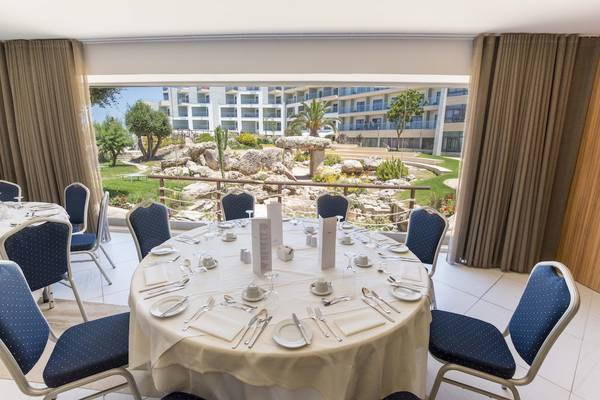 Ein Tisch im Restaurant des Doubletree by Hilton Malta, mit Blick auf eine Gartenlandschaft.