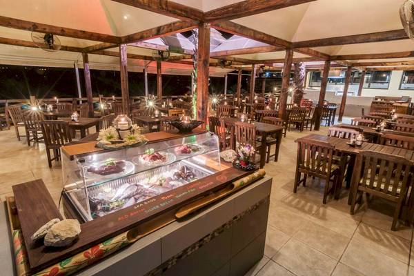 Innenbereich des Doubletree by Hilton Malta Restaurants mit vielen Tischen und Stühlen.