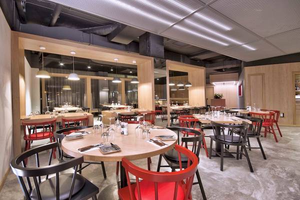 Innenbereich des Restaurants im Doubletree by Hilton Malta mit runden Tischen und Stühlen.
