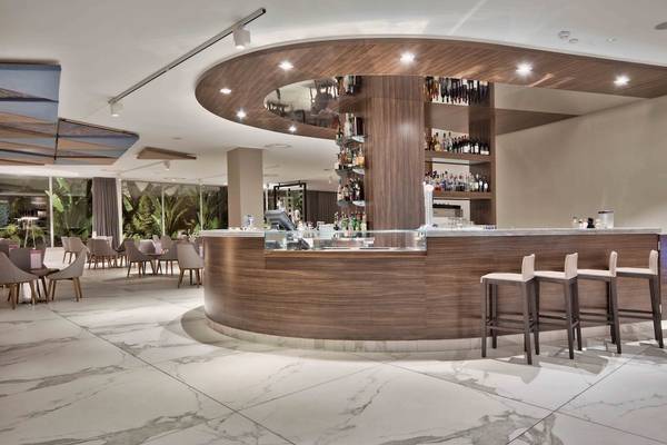 Bar im Doubletree by Hilton Malta Hotel mit Holztheke und Barhockern