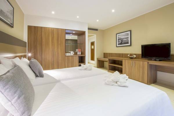 Doppelbettzimmer im Doubletree by Hilton Malta Hotel mit Fernseher und Dekor.