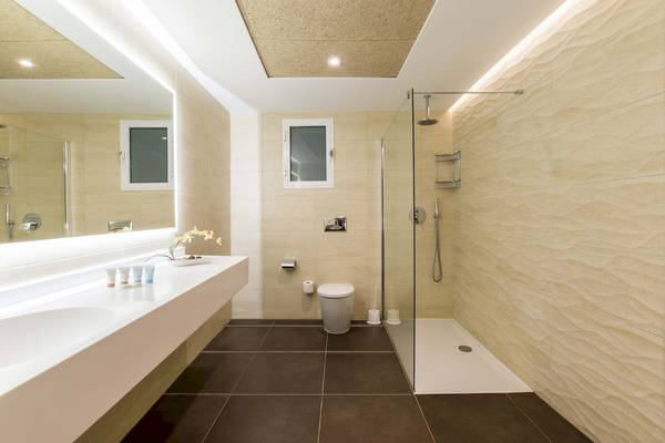 Doppeltree by Hilton Malta Badezimmer mit einer Badewanne, einem Waschbecken und einer Toilette.