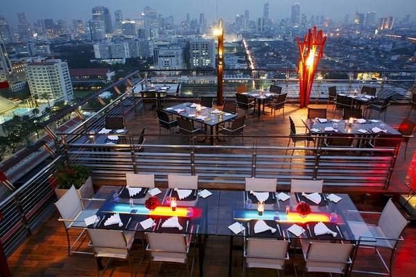 Dachterrasse des Siam@Siam Design Hotels in Bangkok mit Blick auf die Stadt bei Nacht.