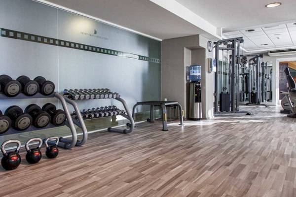 Fitnessstudio im AX The Victoria Hotel mit verschiedenen Gewichten und Geräten.