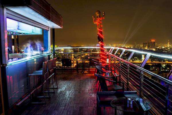 Abendaufnahme der Terrasse des Siam@Siam Design Hotels in Bangkok mit Bar und Blick auf die Stadt