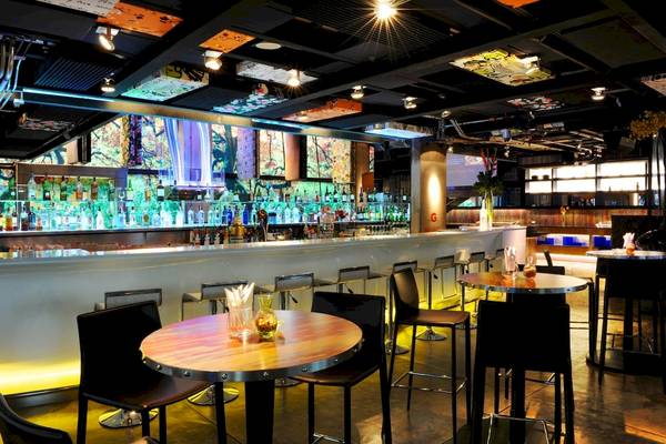 Innenansicht der Bar im Siam@Siam Design Hotel Bangkok mit vielen Gläsern und leuchtenden Lichtern.