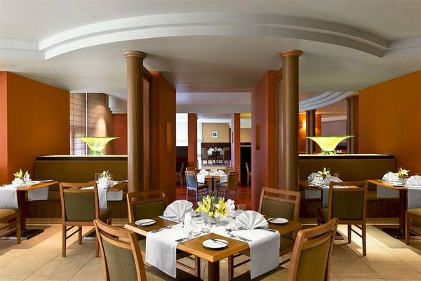 Innenansicht des Restaurants im Malta Marriott Hotel & Spa mit gedeckten Tischen und Stühlen.