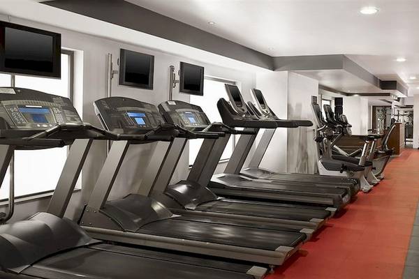 Fitnessstudio im Malta Marriott Hotel & Spa mit mehreren schwarzen Laufbändern und anderen Trainingsgeräten.