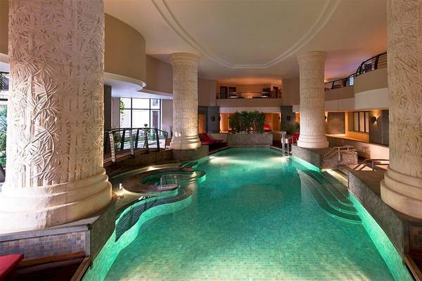 Innenpool des Malta Marriott Hotel & Spa mit großen Säulen und roten Sesseln.