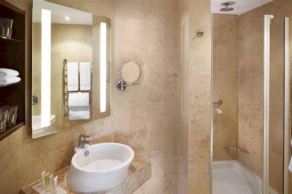 Badezimmer im Malta Marriott Hotel & Spa mit Waschbecken, Spiegel und Dusche.