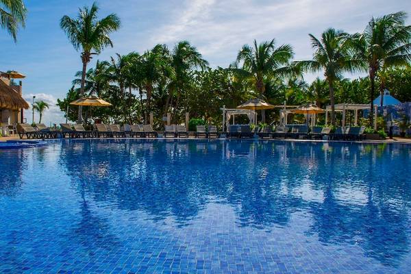 Außenpoolbereich des Catalonia Playa Maroma Hotels mit Liegestühlen und Sonnenschirmen
