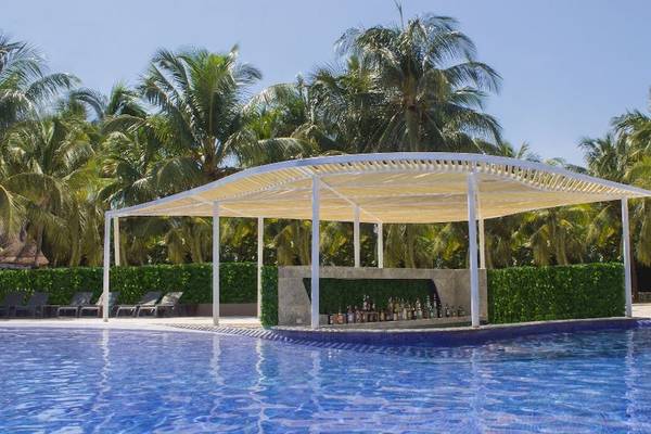 Poolbar im Catalonia Playa Maroma Hotel mit Blick auf einen Pool und Palmen im Hintergrund.