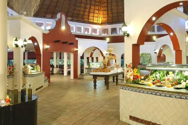 Innenbereich des Catalonia Playa Maroma Hotels mit Speisenbuffet und dekorativen Elementen.