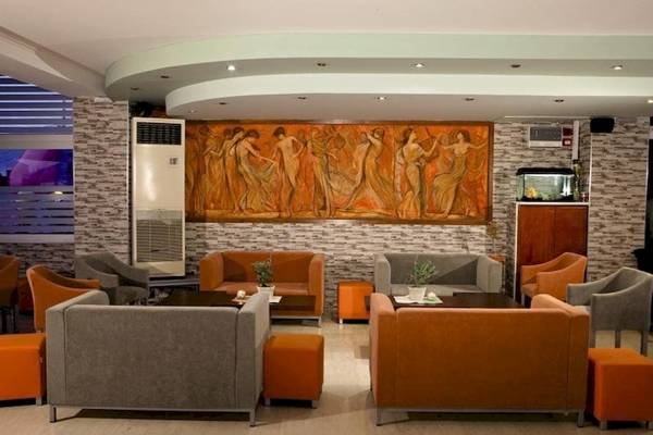 Hotellobby von Sunny Days mit verschiedenen Sofas, Tischen und einer großen Wandmalerei.