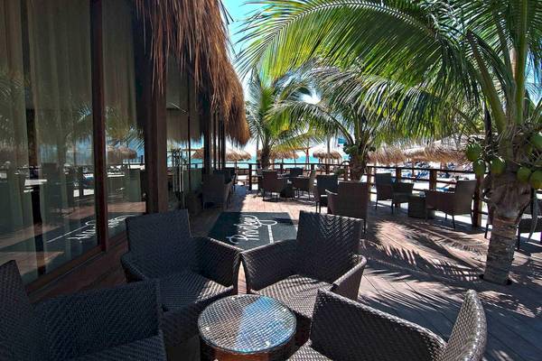 Terrasse des Ocean Maya Royale Hotels mit Blick auf den Strand und Palmen