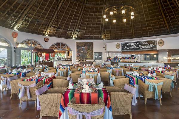 Innenansicht des Restaurants im Ocean Maya Royale Hotel mit bunt dekorierten Tischen und Stühlen.